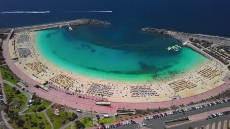 flight over of the sunny amadores beach (playa de amadores) and turquoise sea, gran canaria, canary islands, spain