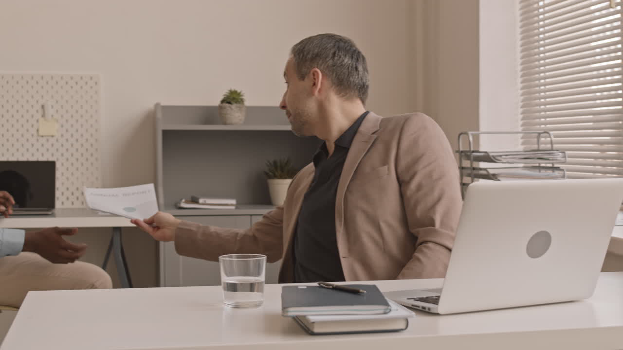 Man Sharing Documents with Colleague in Office