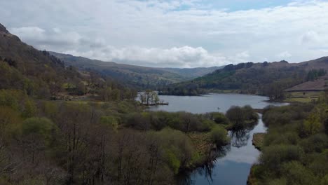 Un-Tiro-Inclinado-Hacia-Arriba-Del-Reflejo-Perfecto-De-Los-árboles-A-Orillas-Del-Río-Rodeado-De-Colinas