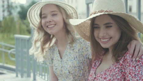 two happy friends wearing summer hats