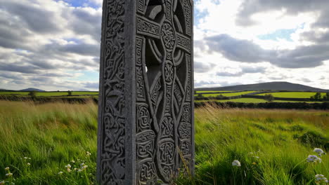 intricately carved celtic cross in a rural landscape