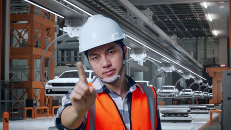 primer plano de un ingeniero masculino asiático con casco de seguridad desaprobando sin señal del dedo índice mientras estaba de pie en la fábrica de automóviles ev