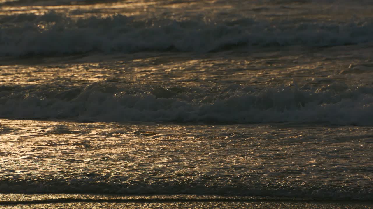 아름다운 바다의 파도와 모래, 황금빛 해가 지는 동안 열대 해변의 근접 텍스처, 고품질의 4k 느린 동작 여행 휴가 개념