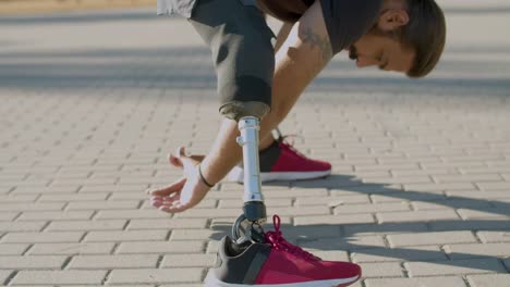 hombre fuerte con una pierna artificial haciendo ejercicios de estiramiento.