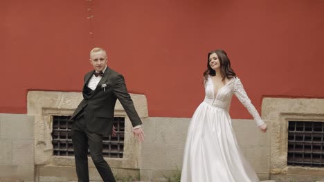 newlyweds, lovely wedding caucasian bride and groom dancing trendy dance celebrating in city street