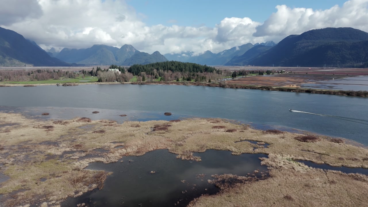 The Scenic View of Pitt River Highlights Calm Waters, Broad Wetlands, and Mountain Ranges in the Distance, Located in Greater Vancouver, British Columbia, Canada - Orbit Drone Shot