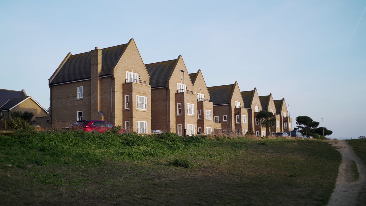 Row of detached new build houses on outskirts of town. Brick homes in countryside. Residential buildings