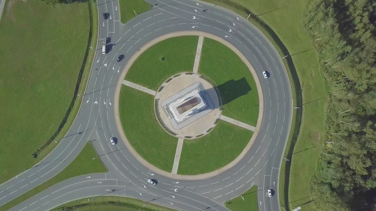 камера дрона вращается вокруг кругового кольца на городском проспекте.