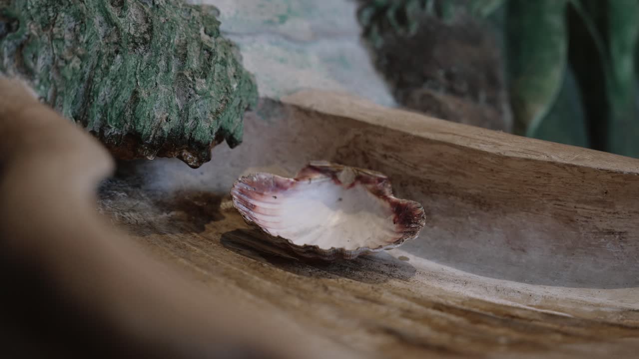 Close up of scallop shell used in baptism placed in a carved wooden basin at a church