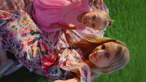 Joyful-mother-and-daughter-grimacing-for-mobile-phone-camera-at-meadow.