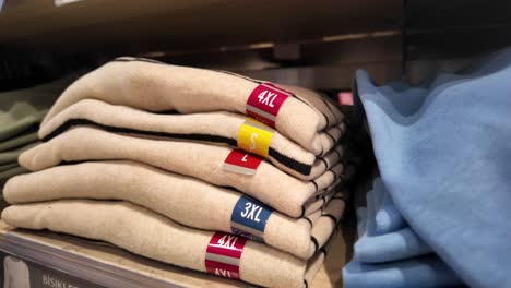 stack of folded sweaters with size tags