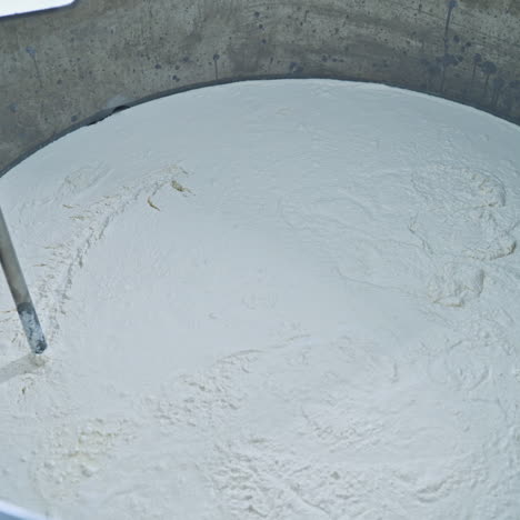 slow motion of mixer in metal bowl for making cheese. factory equipment. metal mixing apparatus boils and mix milk for making cheese at milk products making factory.