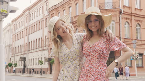 two friends in stylish dresses on a city street