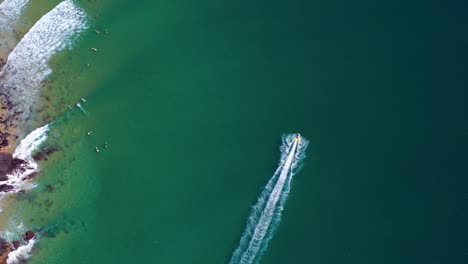 Jetskifahren---Jetskifahrer-Hinterlässt-Im-Sommer-In-Noosa-Heads,-Australien,-Kielwasser-Im-Blauen-Meer