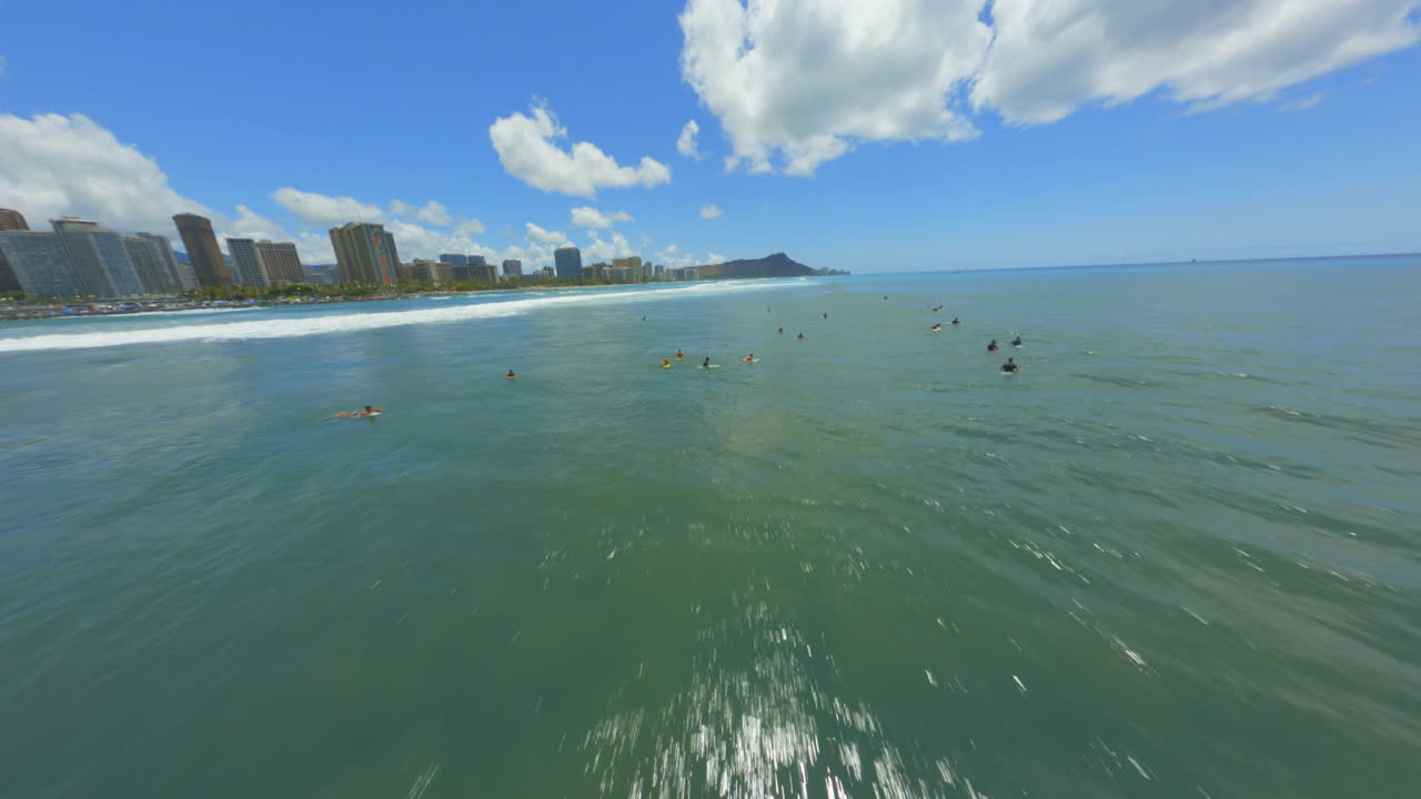 와이키키에서 서퍼 위로 치솟고 fpv 드론이 다이아몬드 헤드와 호놀룰루를 향해 질주합니다.