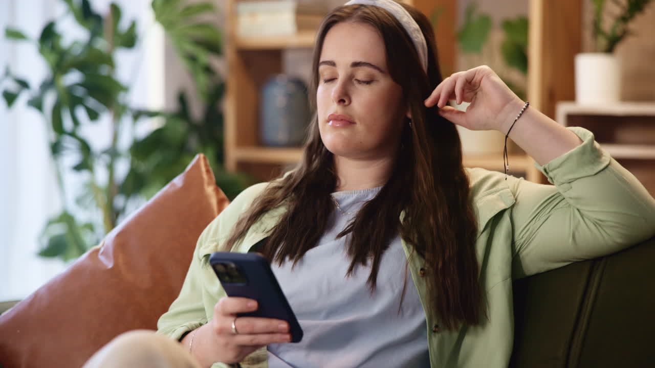 mujer sentada en un sofá usando un teléfono inteligente