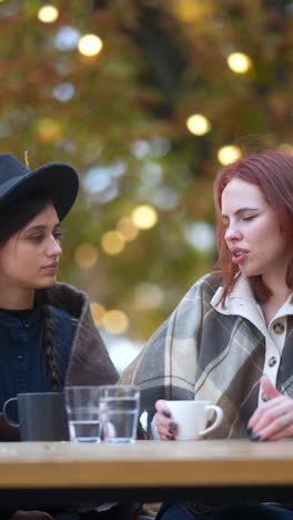 two women talking in an outdoor cafe