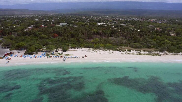 Carrellata aerea su barriera corallina, spiaggia sabbiosa e paesaggio idilliaco illuminato dal sole - Spiaggia di Pedernales, Repubblica Dominicana.