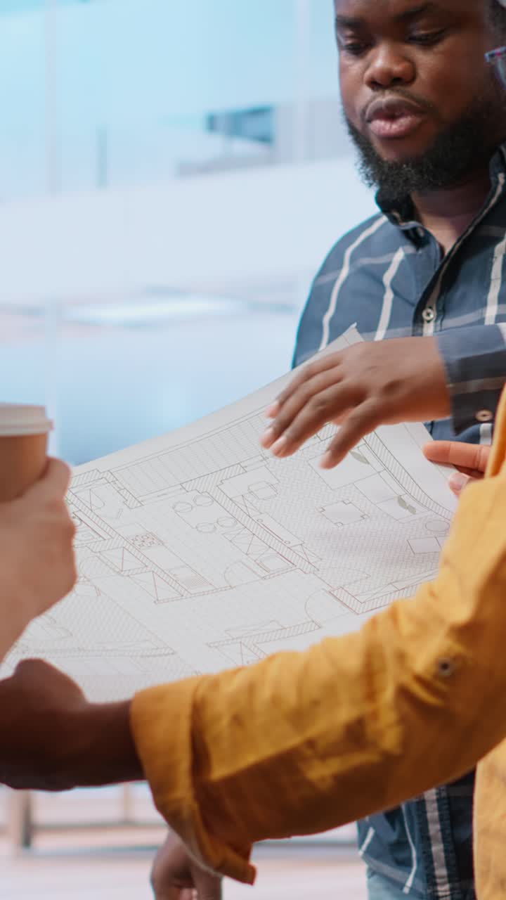 Architects Discussing Building Plan and Blueprint in Office
