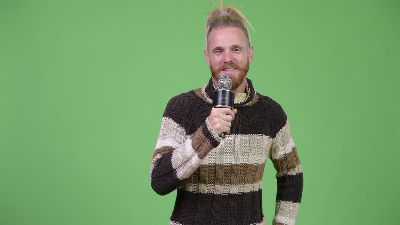 feliz hombre barbudo cantando con el micrófono listo para el invierno