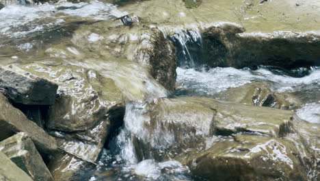 Creek-on-stones-in-forest-macro.-Tiny-waterfall-on-river-rapid.-Clean-water-flow