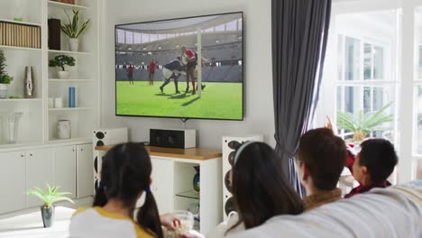 composite of happy family sitting at home together watching rugby match on tv