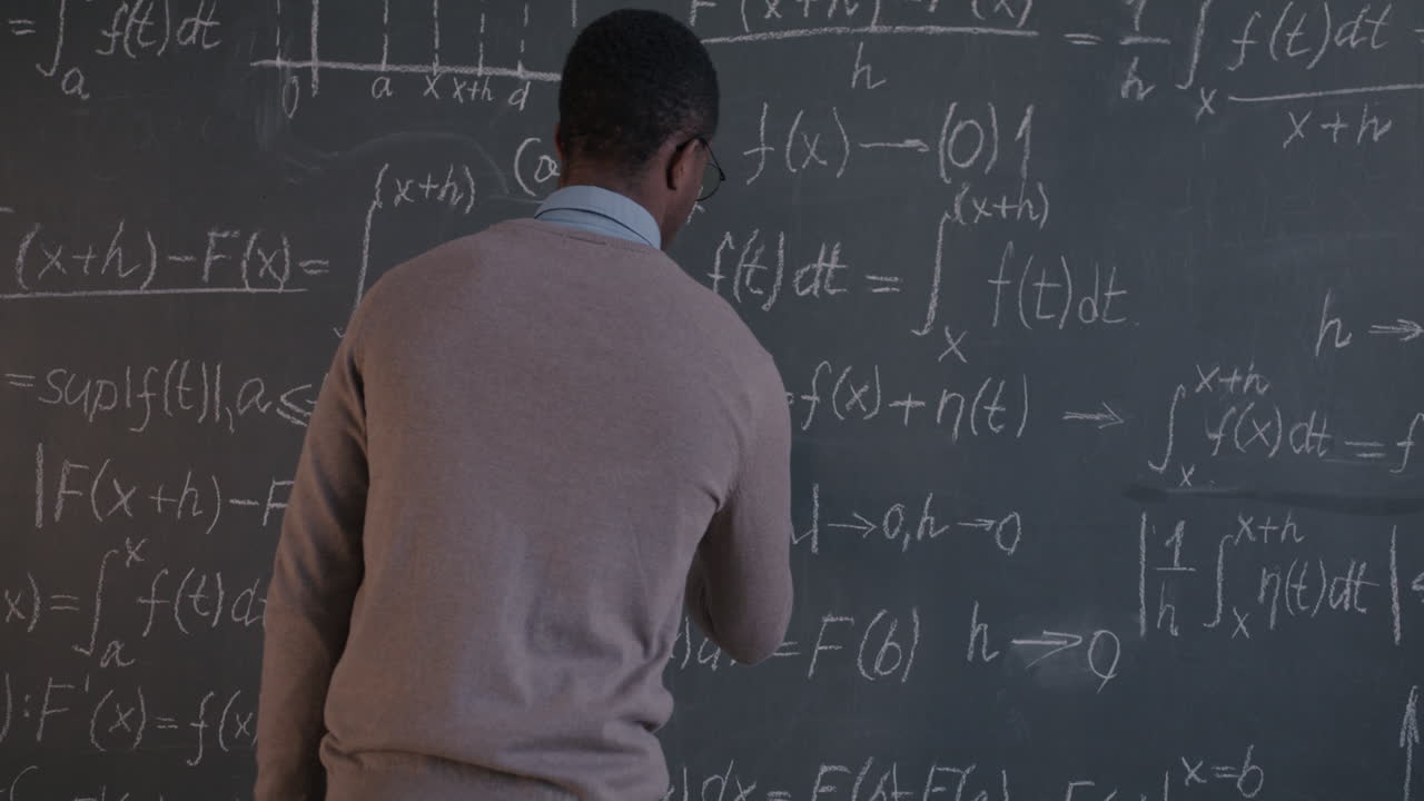 Teacher Explaining Mathematics on Chalkboard