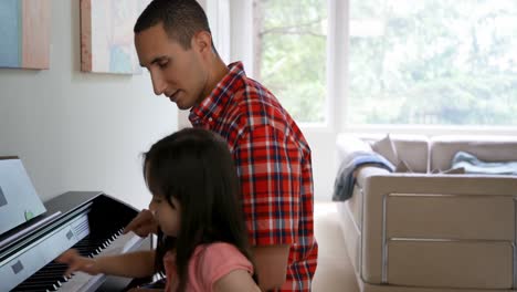 Father-teaching-his-daughter-to-play-piano-4k