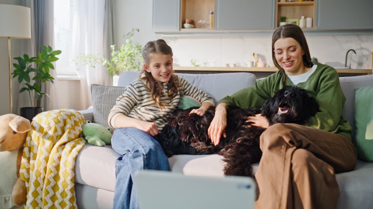 Nærbilde av nettbrett brukt av familie. Avslappet og bekymringsløs mor og barn hilser på nett.