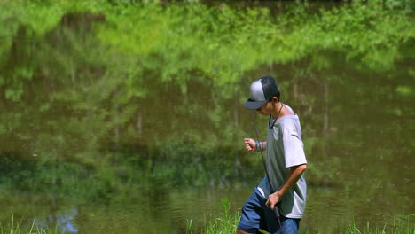 teenager holding a fishing rod on a sunny afternoon with a reflective water backdrop