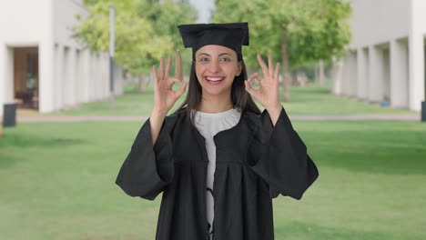 feliz chica graduada de la universidad india mostrando un signo de bien