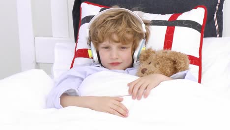 young boy on bed listening to music