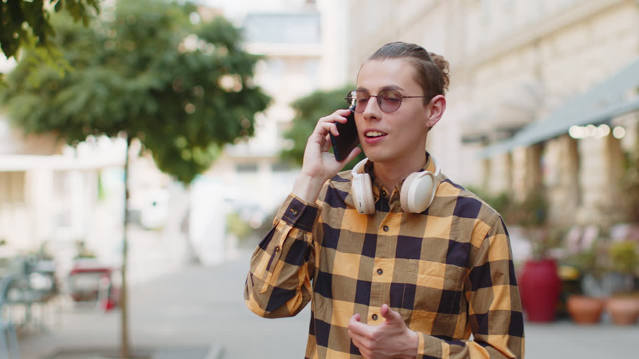 Man tourist having remote conversation speaking talking by smartphone with friend good happy news