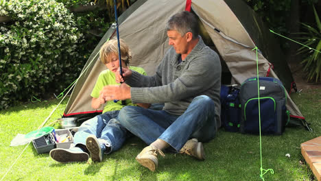 Man-showing-son-how-to-use-a-fishing-rod