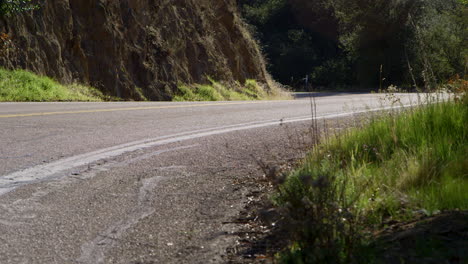 A-person-riding-a-motorcycle-wearing-full-red-protective-gear-on-a-mountain-road-in-the-desert-of-California