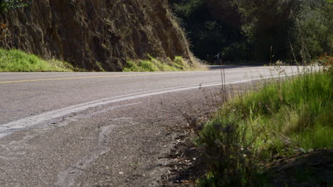 una persona que conduce una motocicleta con equipo de protección rojo completo en una carretera de montaña en el desierto de california