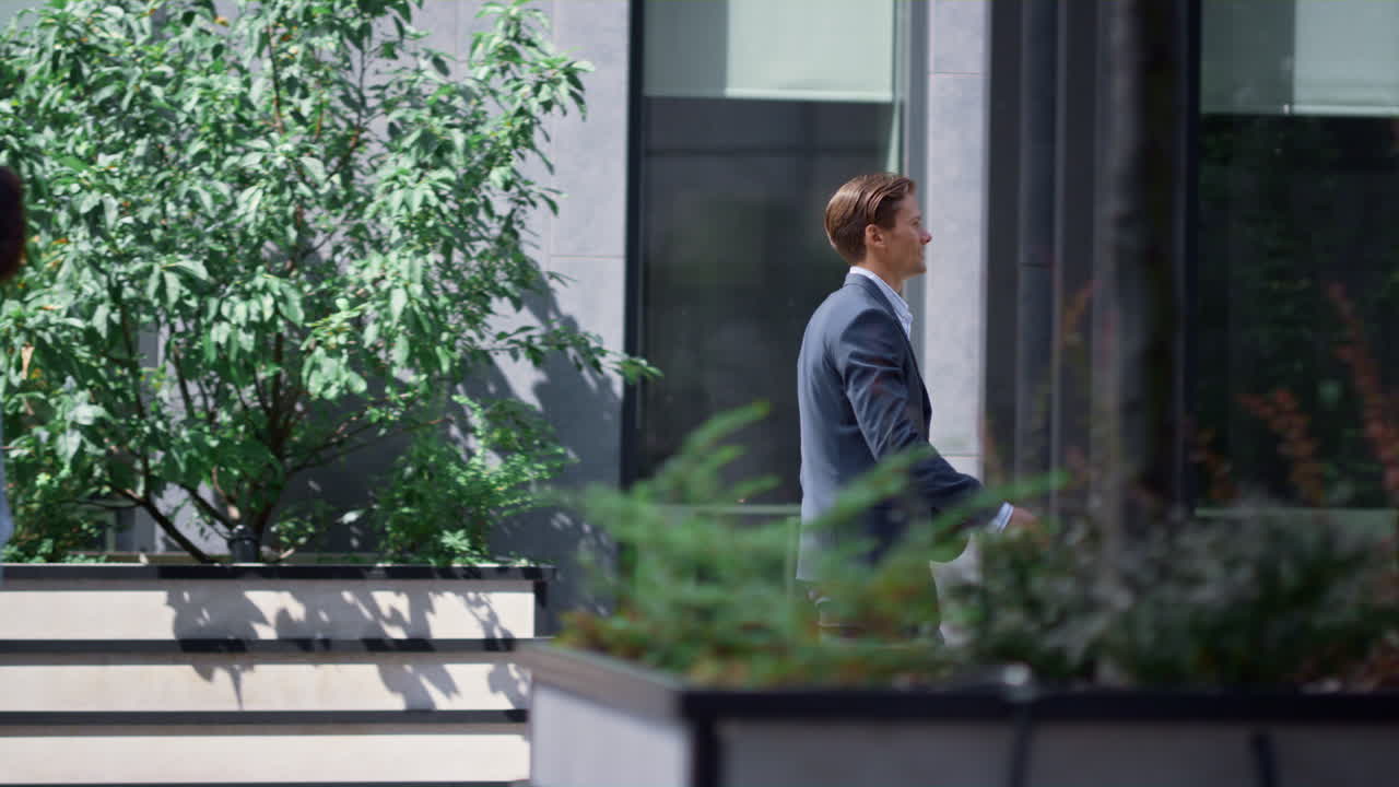 el gerente del banco va a dar un paseo en el almuerzo en una calle moderna del centro de la ciudad.