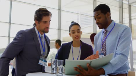 Multi-ethnic-business-people-discussing-over-file-during-a-seminar-4k