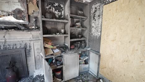 burnt cupboard after a house fire with belongings on shelves