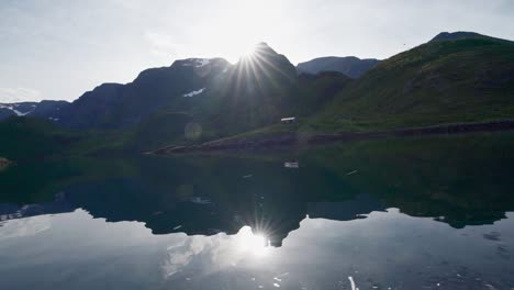 reflejo de la montaña en el río bajo un clima cálido en noruega - vista desde un velero