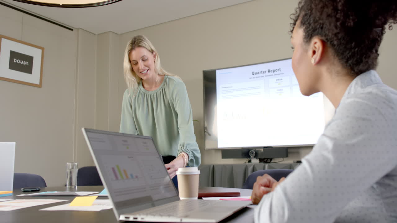Diverse business people using laptops at conference table with copy space