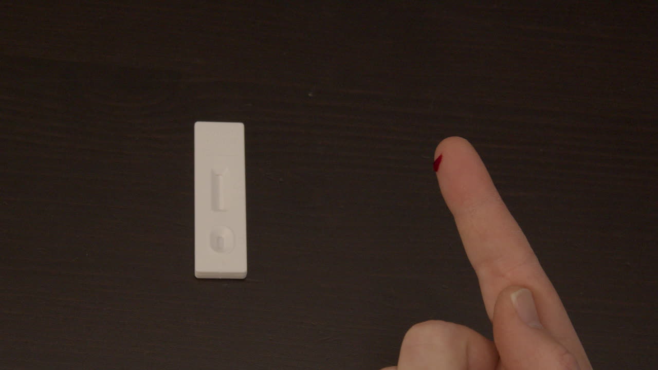 Finger being punctured with safety needle in preparation of Covid-19 self test