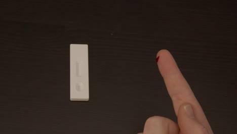 finger being punctured with safety needle in preparation of covid-19 self test