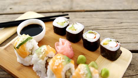 primer plano de varios sushi en bandeja con salsa