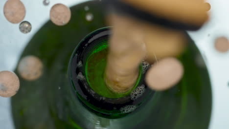 la tapa de la botella de lager apareciendo de cerca. la cerveza carbonatada dorada salpicando en cámara lenta