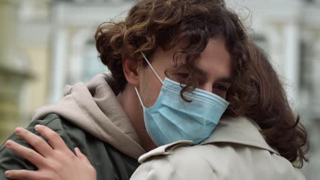 love couple hugging on urban street. woman in mask leaning to man outdoor.