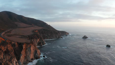 Vista-Aérea-De-Los-Acantilados-Escarpados-De-Big-Sur-Y-El-Paisaje-Marino-Durante-La-Puesta-De-Sol-En-California,-Ee.uu.