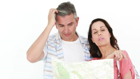 una pareja sonriente y perdida mirando el mapa.