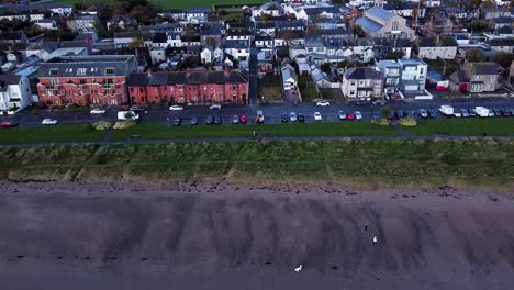 Luftaufnahme-Einer-Drohne,-Die-Rückwärts-Aus-Einer-Wohnküstenstraße-über-Dem-Sandstrand-Von-Skerries-Beach,-Irland,-Herausfuhr