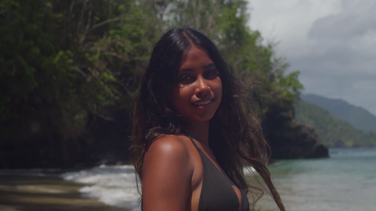 The Caribbean sun shines down on a young East Indian girl enjoying the beach in her bikini.